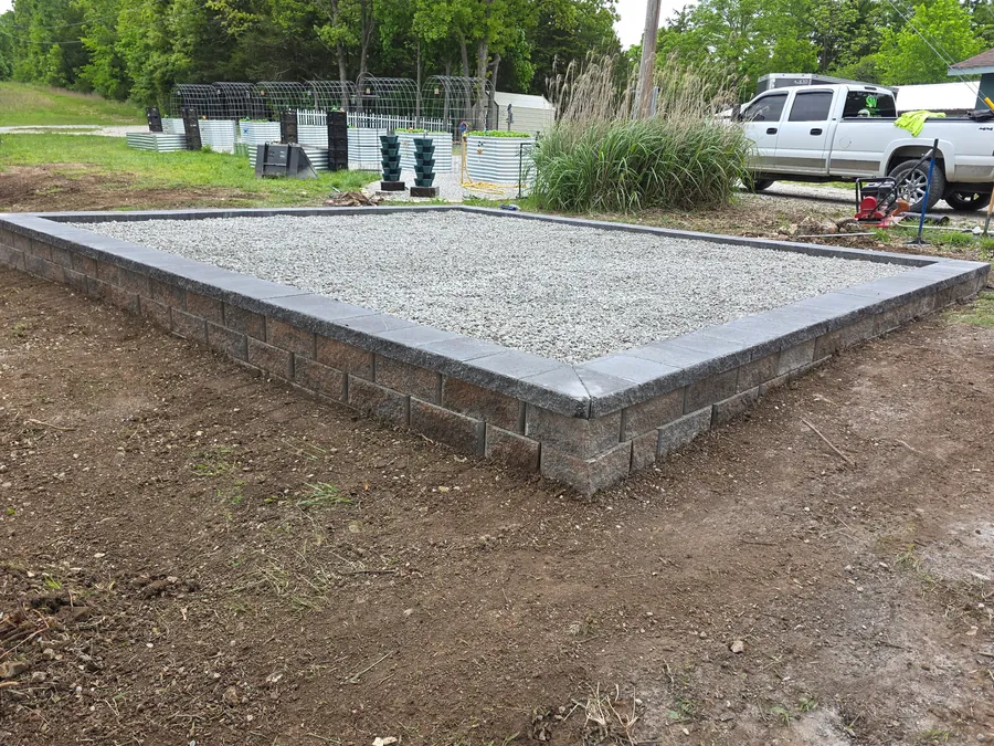 Retaining wall and gravel pad built to manage slope and surface water